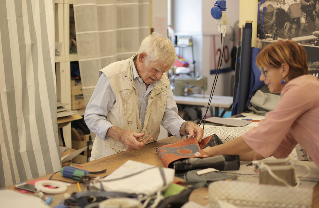 Maker's hands stitching a full-grain leather dog collar at a workshop bench with hand tools and thread
