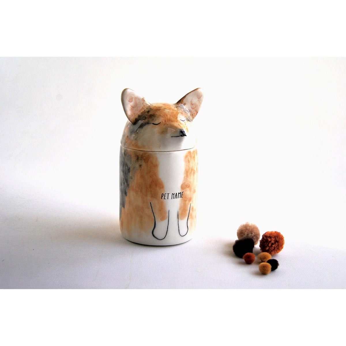 Personalized ceramic dog urn with a painted PET NAME example on its body